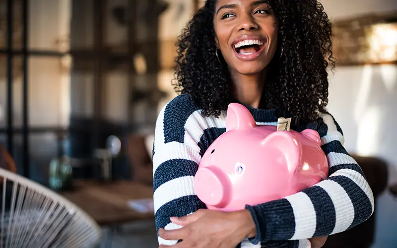 smiling woman with piggy bank
